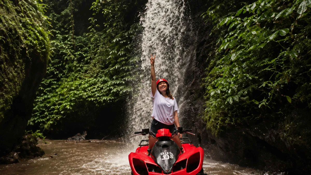 ATV riding through a long natural cave tunnel on a jungle and waterfall ATV tour in Ubud, Bali